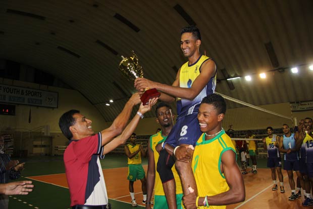 Le capitaine Evans Sauteur, tout sourire, recevant le trophée du vainqueur des mains du Directeur des Sports du MJS, Ram Lollchand.